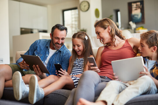 Technology, streaming and a happy family on the sofa for internet, social media and communication. Smile, bonding and a mother, father and children with a tablet and phone for online games at home