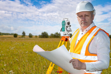 Man surveyor. Guy creates topographic drawings. Surveyor looks into camera. Worker near geodetic...