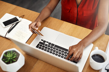 Business woman, laptop and paying with credit card for online shopping, e-commerce or internet store. Hands of a female entrepreneur at desk for banking, booking or fintech payment on a website