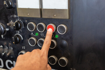 ็Hand of engineer turn power button on panel control machine. mechanic's hands Pressing the work...