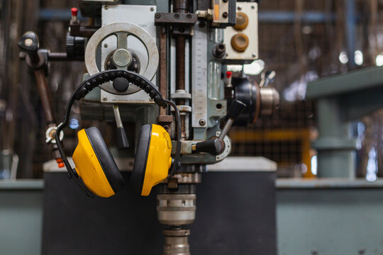 Soundproof headphones for industry plants hanging on lathe in factory. headphones protection equipment for use in industrial work. protection equipment ear safety.