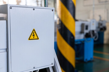 Hight voltage sign on machine at industrial plant. Occupational and safety caution sign for worker...