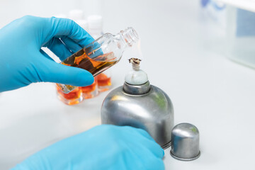 Scientist use alcohol lamp burn glass bottle with solution for sterilize disease or bacteria in water testing in laboratory.