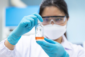 Professional scientist holding solution bottle for test coliform or bacteria in water and ice at chemistry laboratory.