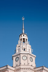 Fototapeta na wymiar Voronezh, Russia, November 30, 2022: The spire with the clock of the administrative building against the blue sky