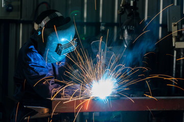 A Workers are welding steel at a heavy industry factory. Industrial safety first concept.