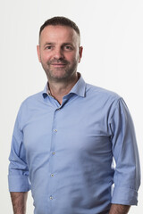 casual businessman wearing formal business clothes smiling at camera with crossed hands isolated over gray background.