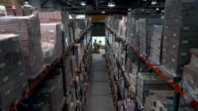 Inside of large full warehouse, pallets of cardboard boxes ready for shipment