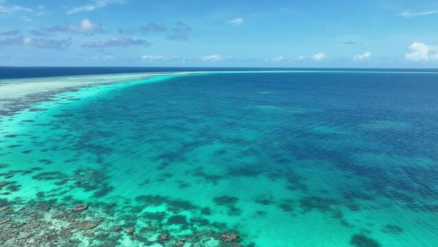 Ravishing Coral Reef Under Clear Blue Ocean In Tropical Paradise Island In The Philippines. aerial pullback