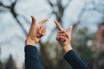 木の手話を表している黒い服の女性
