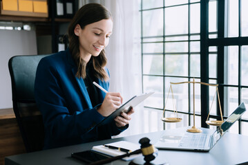 justice and law concept.Male judge in a courtroom  the gavel, working with smart phone and laptop and digital tablet computer on wood table