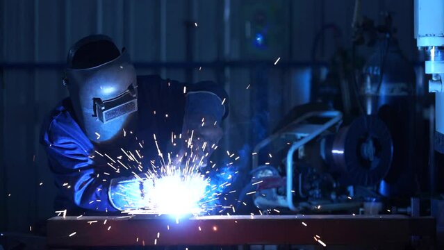 A workers wearing industrial uniforms and welded iron mask at steel welding plants, Industrial safety first concept. VDO.