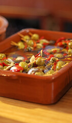 Spanish tapas. Green and black olives with anchovies and peppers. Selective focus