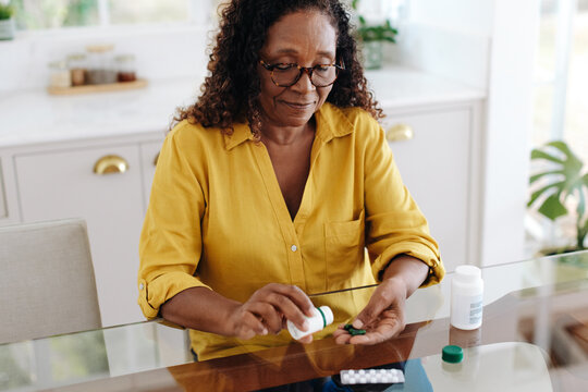 Woman With A Chronic Health Condition Taking Medication At Home