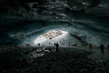 entrance to an deep blue ice ice cave in the Valais Alps
