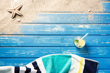Towel on blue wood plank background with towel and cold drink. Summer background.