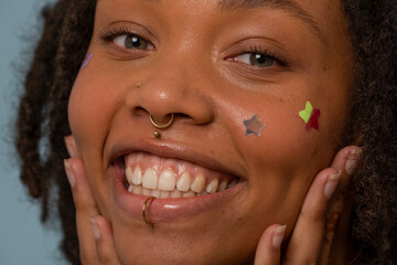 Portrait of young woman wearing star stickers on face