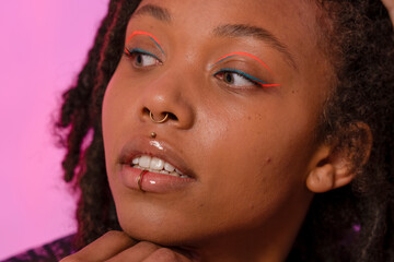 Young woman wearing pink eyeliner and piercings