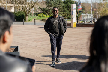 Obraz premium Smiling male student walking on campus