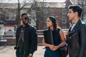 Group of student friends walking on campus - obrazy, fototapety, plakaty