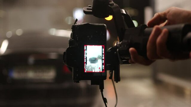 Screen of Digital Camera in Vertical Orientation Attached to Gimbal Recording Video of Car in Carwash