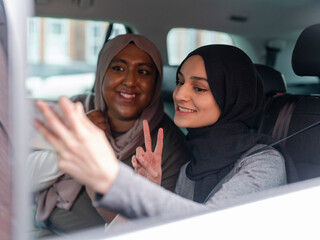 Smiling women taking selfie in car