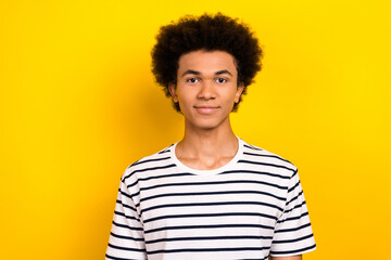 Photo of cute youngster student guy calm kind glad smiling wear striped white black t-shirt isolated yellow color background