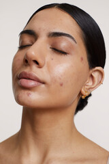 Portrait of young woman with closed eyes against white background