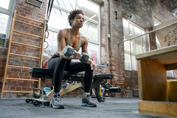 Woman doing weight training with dumbbell on gym