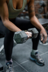 Fototapeta na wymiar Woman holding dumbbell during weight training on gym