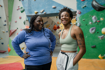 Portrait of mother and daughter standing in front of climbing wall