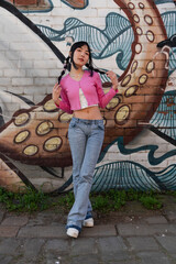 Portrait of young woman standing against graffiti wall