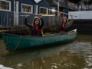Obraz premium Two young women sitting in canoe