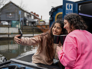 Cheerful women smiling to camera on boat