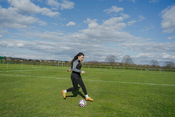 Young woman playing soccer outdoors