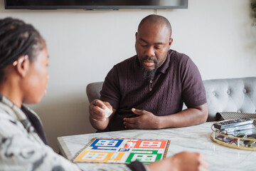 Mature couple playing board game at home