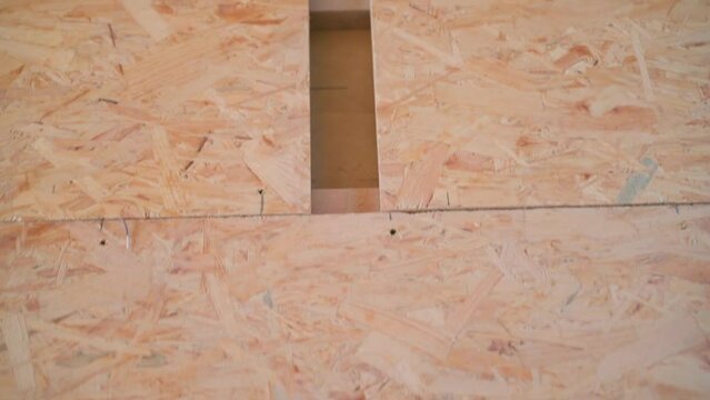 Close-up of an oriented strand board primary floor. The process of laying and screwing the floor from OSB sheets