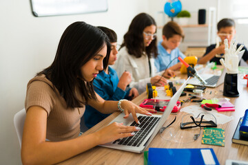Group of smart teens learning to code during a robotics class