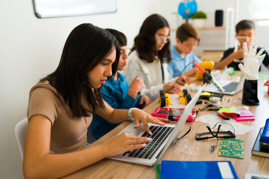 Group of smart teens learning to code during a robotics class