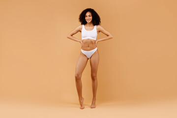 Full body length shot of slim black woman posing in white underwear, showing perfect figure, copy...