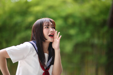 Fototapeta premium Japanese high school student with happy and shouting on copy space in bamboo background