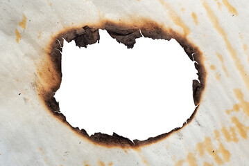 A hole in the scorched old yellow, crumpled paper. Baking paper after fire. Fire