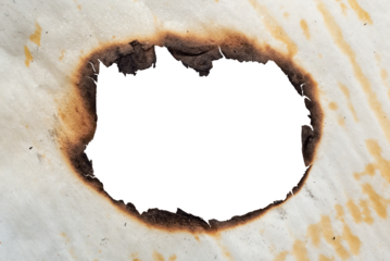 A hole in the scorched old yellow, crumpled paper. Baking paper after fire. Fire