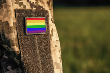 Close up millitary woman or man shoulder arm sleeve with LGBT Pride flag patch. Troops army,...