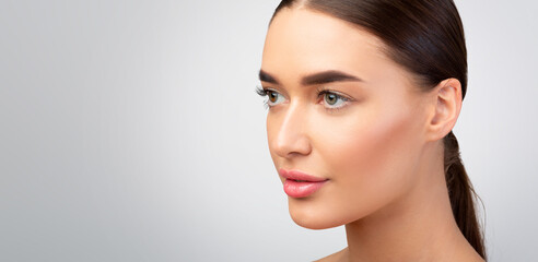 Naklejka premium Young Lady With Perfect Skin Looking Aside, Gray Background