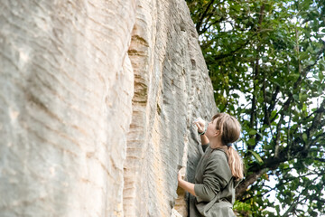 young active teen girl doing outdoor rock climbing bouldering on natural cliff. High quality photo © Alena Yakusheva