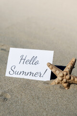 HELLO SUMMER text on paper greeting card on background of starfish seashell summer vacation decor. Sandy beach sun coast. Holiday concept postcard. Getting away Travel Business concept