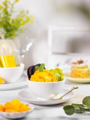 A bowl of ice cream with mango and avocado flavour on the table