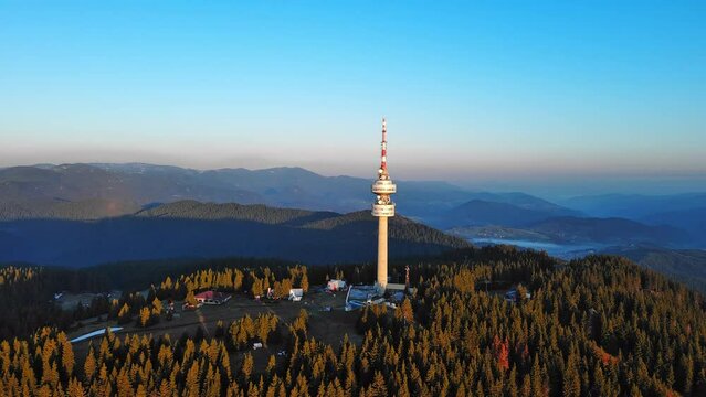 Tower Snezhana on peak of Snezhana covered with spruce forests in Rhodope mountains