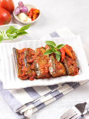 Terong Balado, Fried Eggplant with sambal balado. Indonesian autenthic cuisine from Padang, West Sumatra. Served in white square plate